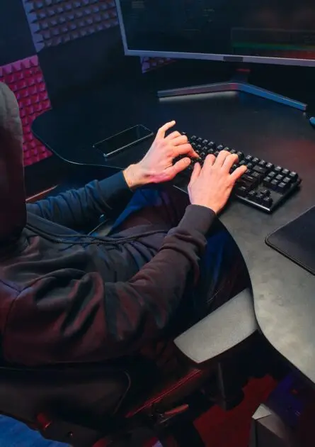 Aadhaar OTP Scam: unrecognizable person in a black hoodie typing