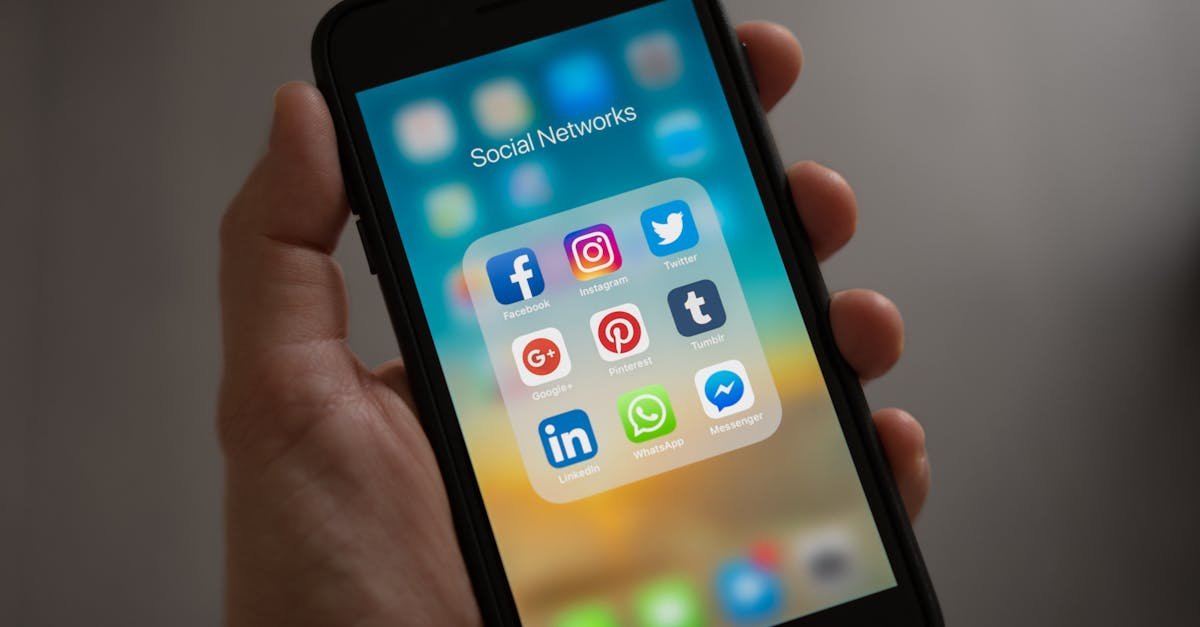 भारत में फेक न्यूज़ : A smartphone displaying various social media icons held in a hand, showcasing modern communication apps.